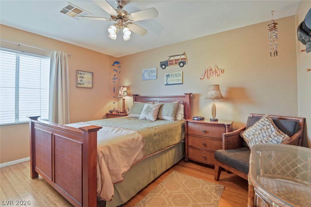 2356 Tilden Way Henderson, NV 89074 - Photo 20 of 30 Hardwood floors and a ceiling fan create a comfortable atmosphere in this well-appointed bedroom.
