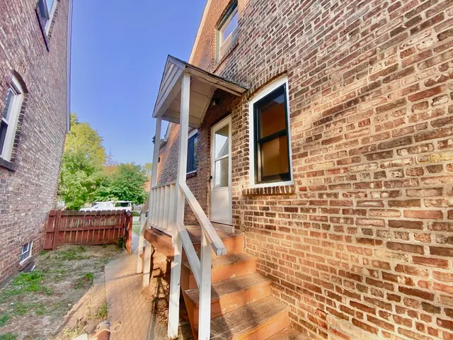a view of backyard of house with wooden fence