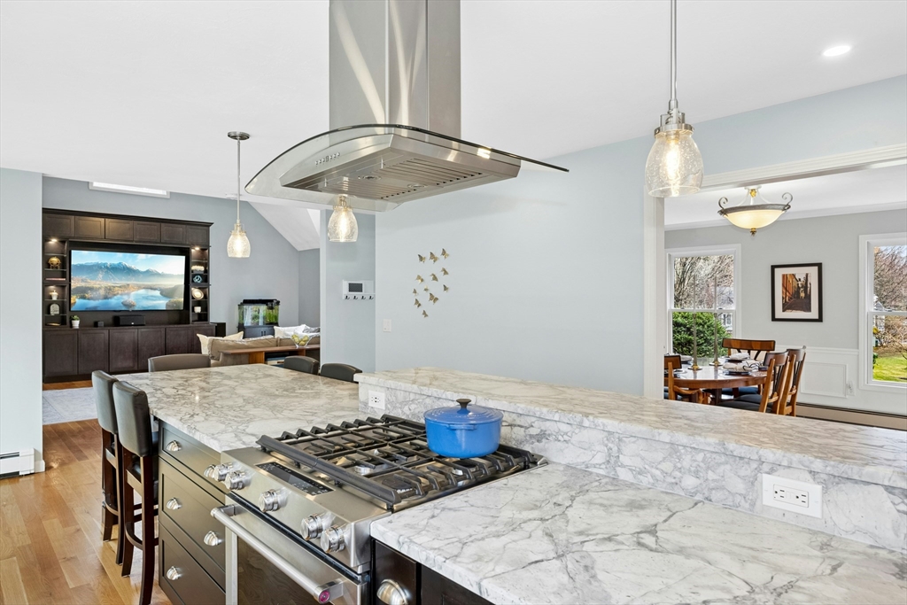 97 Willow Brook Road Holden, MA 01520 - Photo 13 of 42 a kitchen with stainless steel appliances granite countertop a stove a refrigerator a oven a dining table and chairs with wooden floor