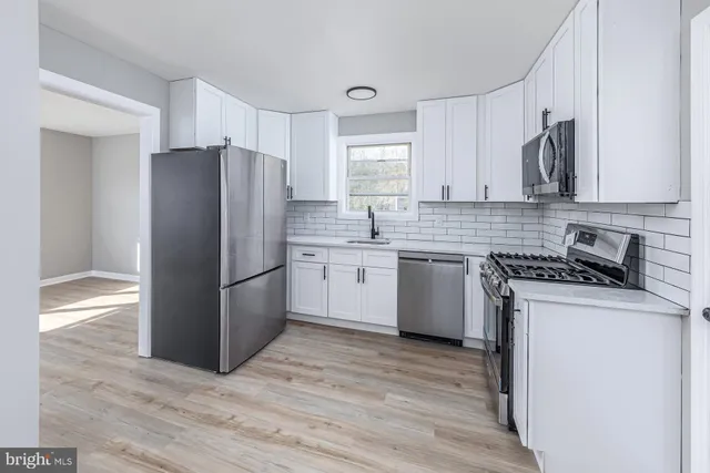 a kitchen with a refrigerator sink and cabinets