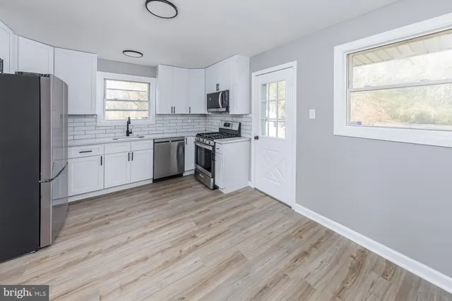 a kitchen with a refrigerator stove top oven and sink