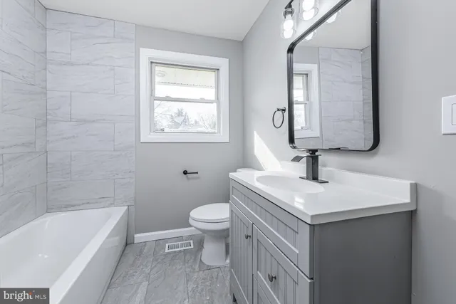 a bathroom with a sink a toilet and bathtub