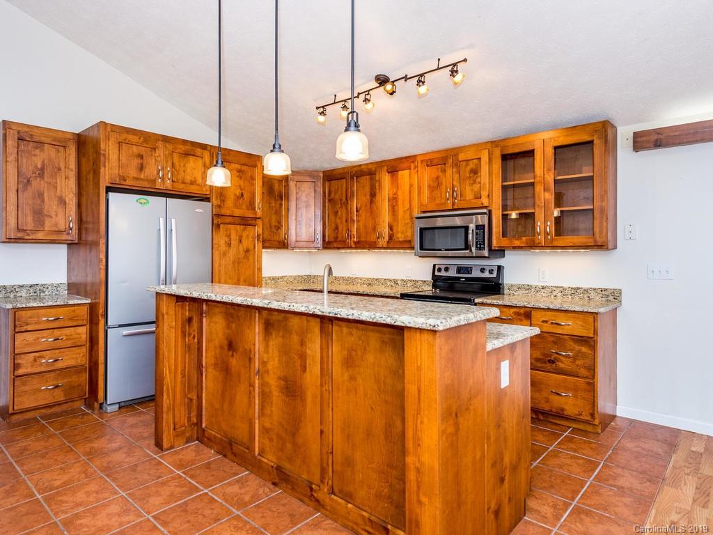 795 Springbrook Farm Road Waynesville, NC 28786 - Photo 11 of 45 a kitchen with stainless steel appliances wooden cabinets a stove top oven a sink and dishwasher