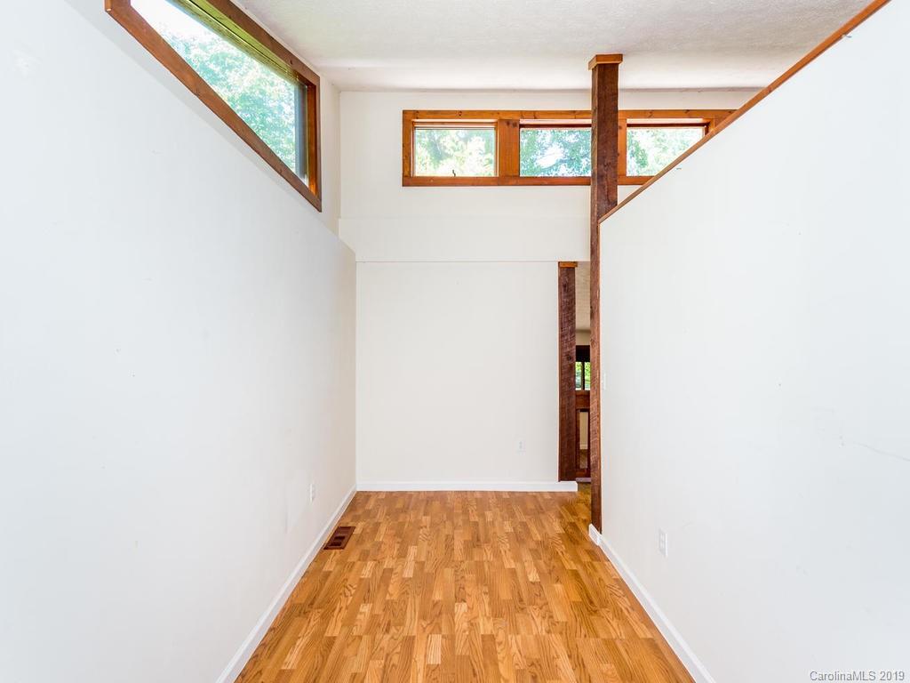 795 Springbrook Farm Road Waynesville, NC 28786 - Photo 13 of 45 a view of a hallway with wooden floor and staircase