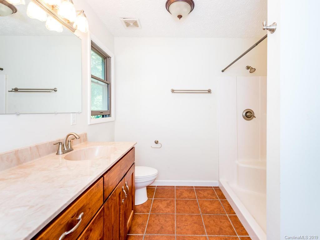 795 Springbrook Farm Road Waynesville, NC 28786 - Photo 19 of 45 a bathroom with a sink a toilet and shower