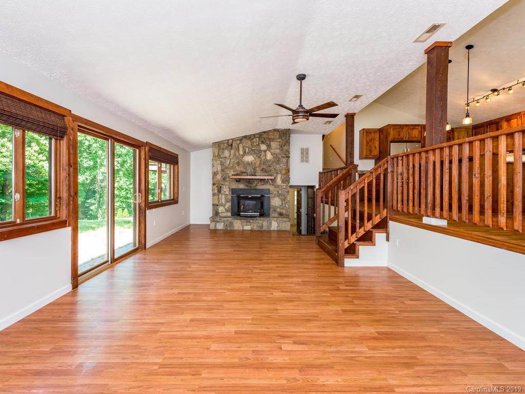 795 Springbrook Farm Road Waynesville, NC 28786 - Photo 3 of 45 a view of a livingroom with furniture hardwood floor and staircase