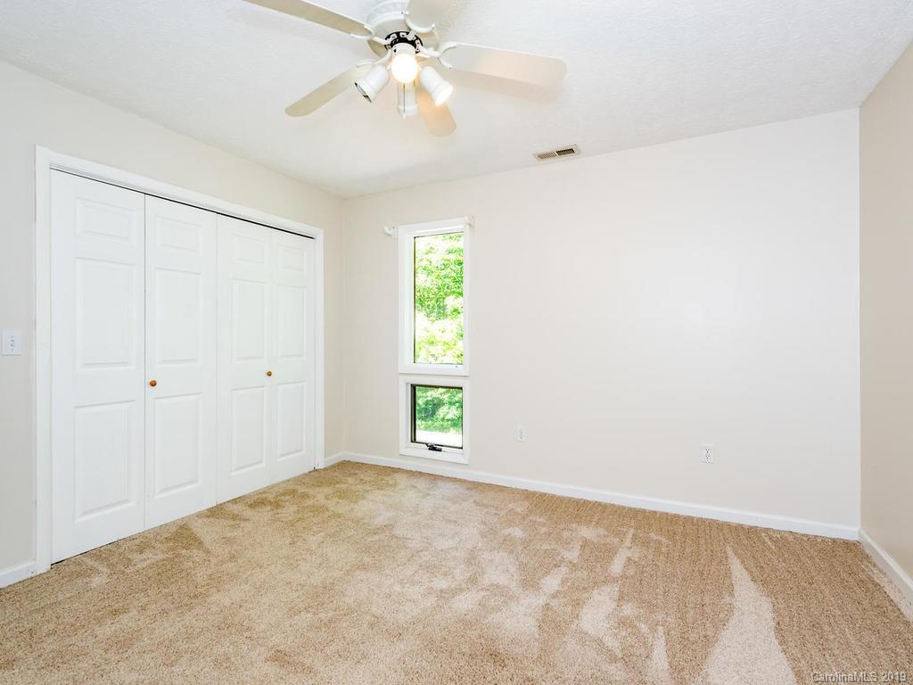 795 Springbrook Farm Road Waynesville, NC 28786 - Photo 22 of 45 an empty room with windows and fan