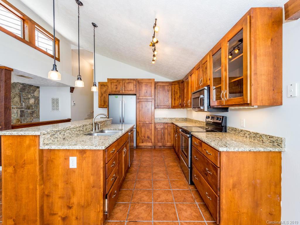 795 Springbrook Farm Road Waynesville, NC 28786 - Photo 10 of 45 a open kitchen with stainless steel appliances granite countertop a sink a counter top space cabinets and a ceiling fan