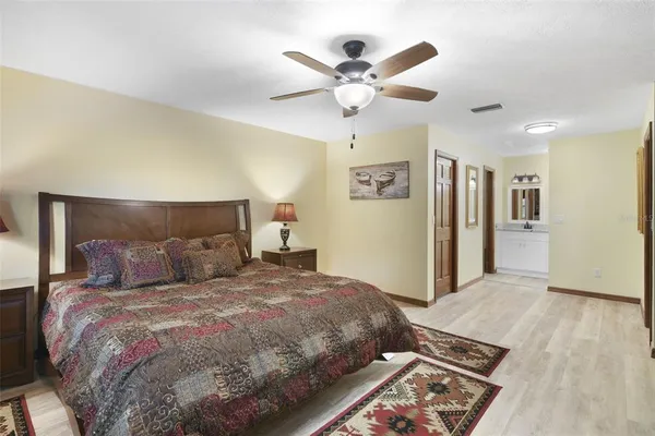 a bedroom with a large bed and a chandelier