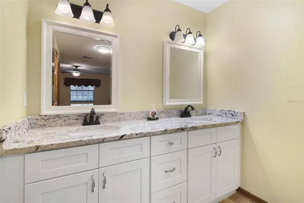 a bathroom with a granite countertop sink double and mirror