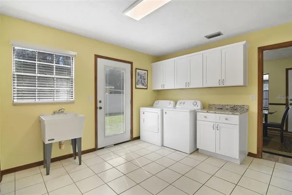 a utility room with cabinets washer and dryer