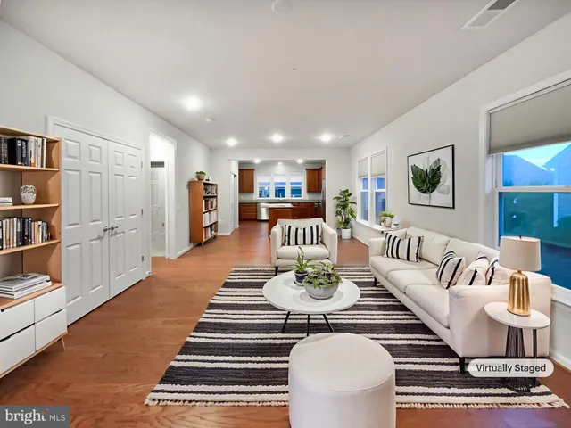 a living room with furniture and a view of kitchen