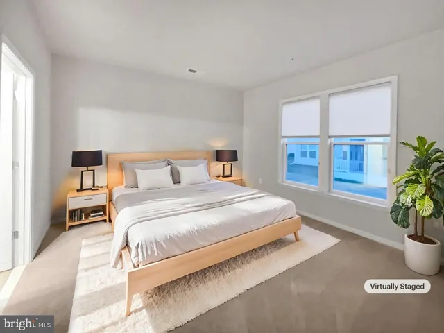 a bedroom with a large bed and a potted plant