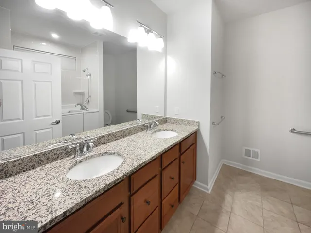 a bathroom with a granite countertop sink and a mirror