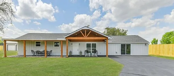 a front view of a house with swimming pool having outdoor seating