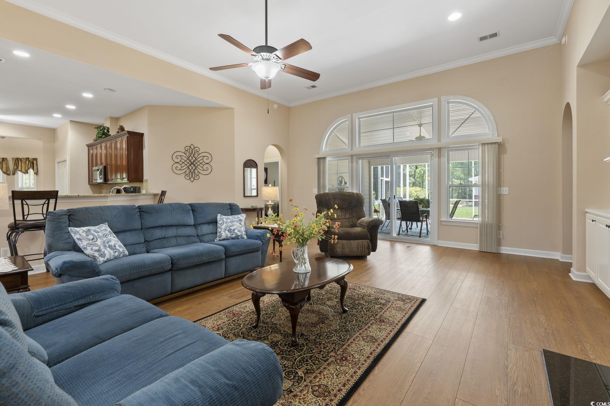 499 Trestle Way Conway, SC 29526 - Photo 6 of 40 Living area with arched walkways, light wood-style floors, a ceiling fan, crown molding, and baseboards