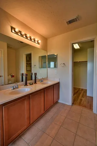 a spacious bathroom with a double vanity sink and a mirror
