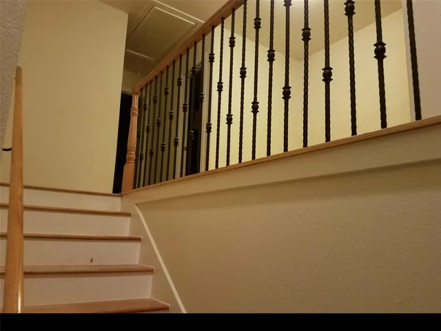 a view of staircase with wooden floor and white walls
