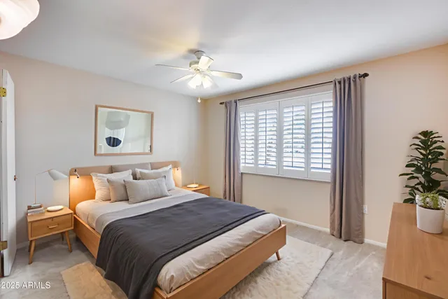 a bedroom with a large bed and a potted plant