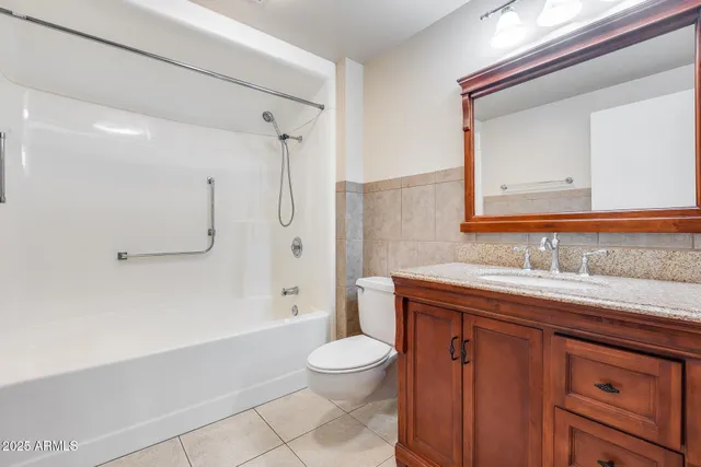a bathroom with a granite countertop sink toilet a shower and a mirror