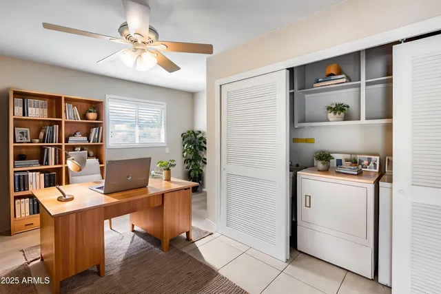 a view of a workspace with furniture and a bookshelf