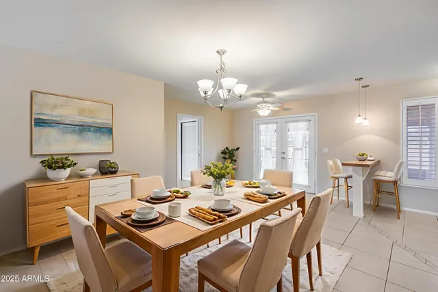 a dining room with wooden floor a chandelier a wooden table and chairs