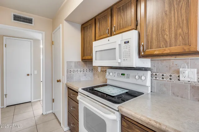 a kitchen with granite countertop cabinets and white appliances