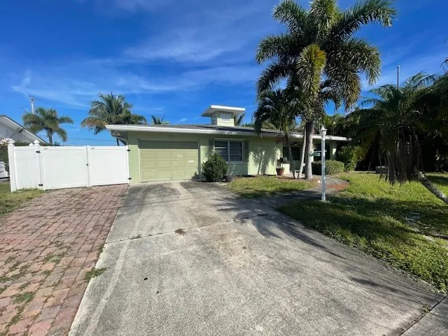 a front view of a house with a yard and palm tree