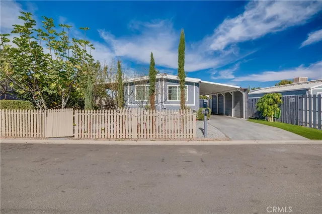 a view of a house with a small yard and wooden fence