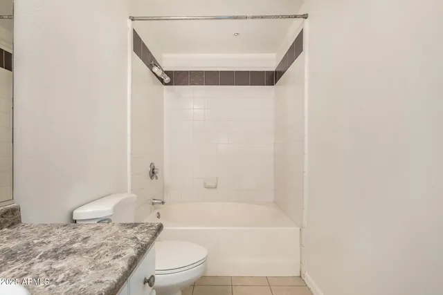 a bathroom with a granite countertop sink a toilet and shower
