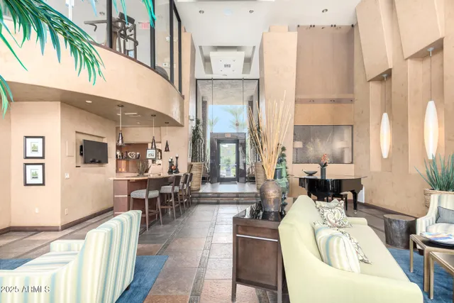 a living room with furniture a large window and a dining table