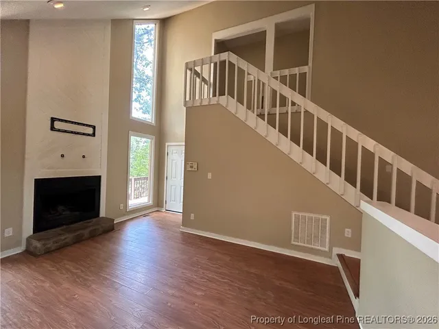 a view of an entryway with wooden floor fireplace and a window