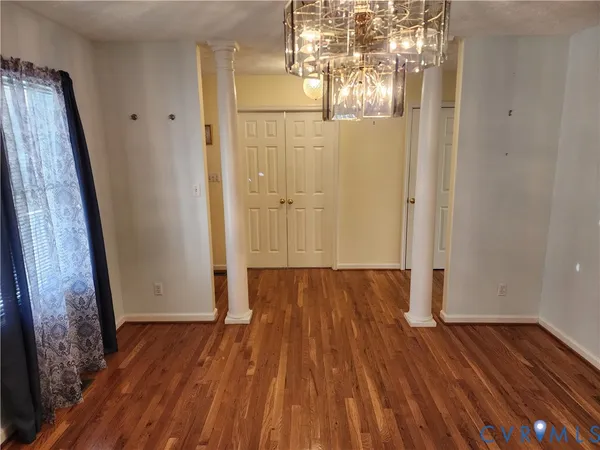 a view of a room with wooden floor and door