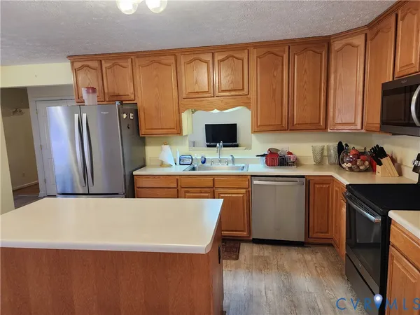 a kitchen with stainless steel appliances a refrigerator sink and microwave
