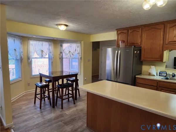 a kitchen with stainless steel appliances wooden floor and dining table