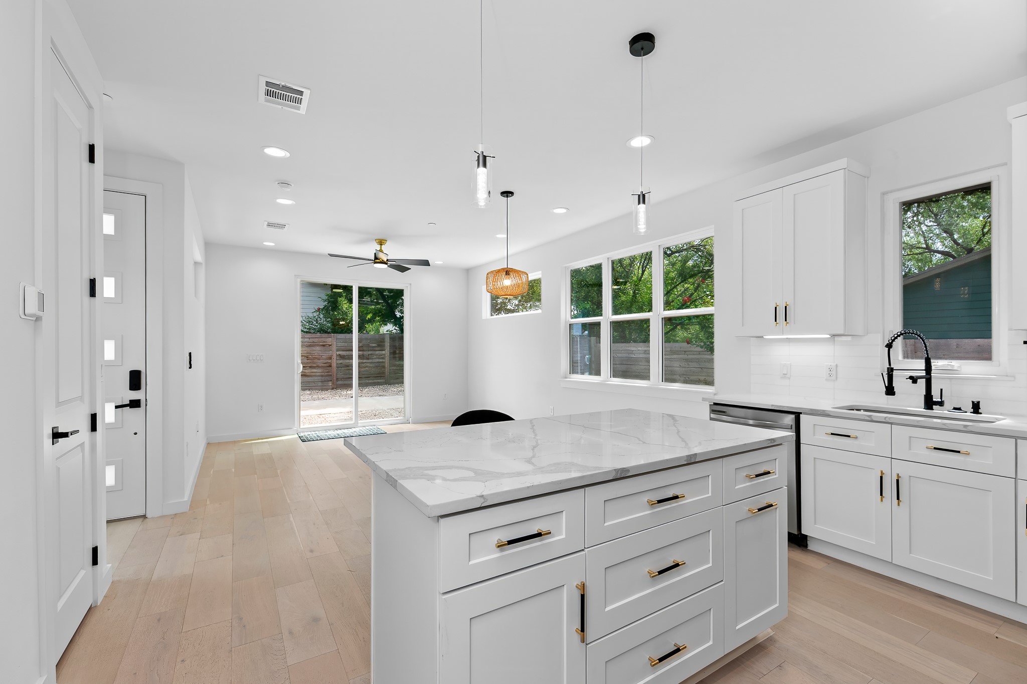 5305 Ledesma Road, Unit 4 Austin, TX 78721 - Photo 17 of 40 A well-appointed kitchen features white cabinetry, stone countertops, and sleek lighting fixtures, creating a crisp, inviting atmosphere.