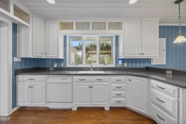 a kitchen with granite countertop white cabinets and white appliances