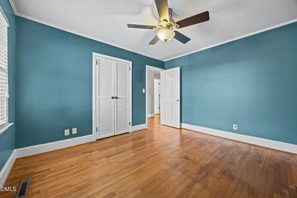 a view of empty room with wooden floor