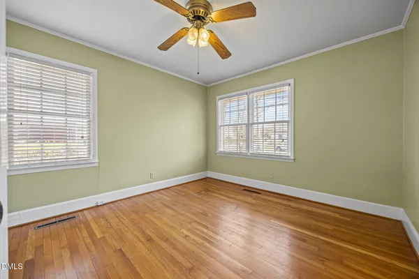 a view of an empty room with window and wooden floor