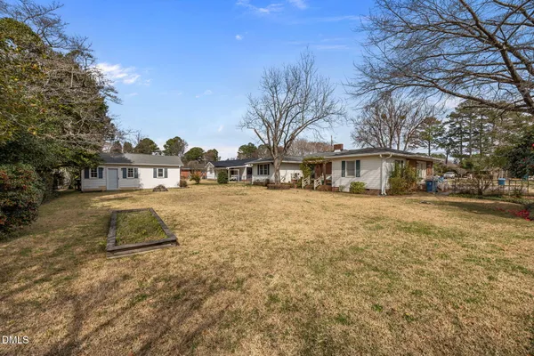 a view of residential houses with yard and trees