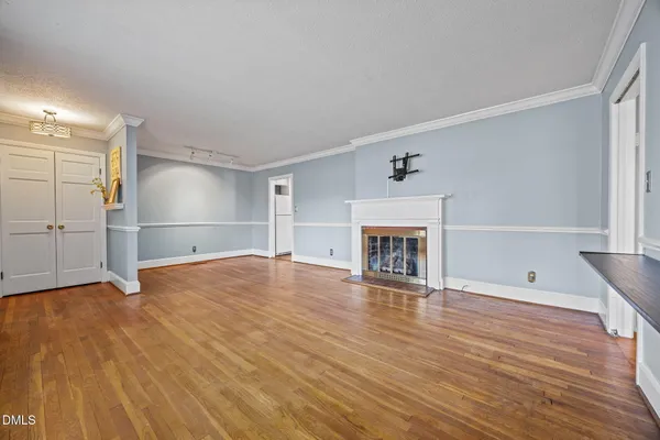 a view of empty room with wooden floor and fireplace