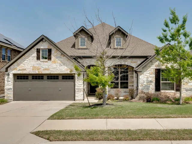 a front view of a house with a yard and garage