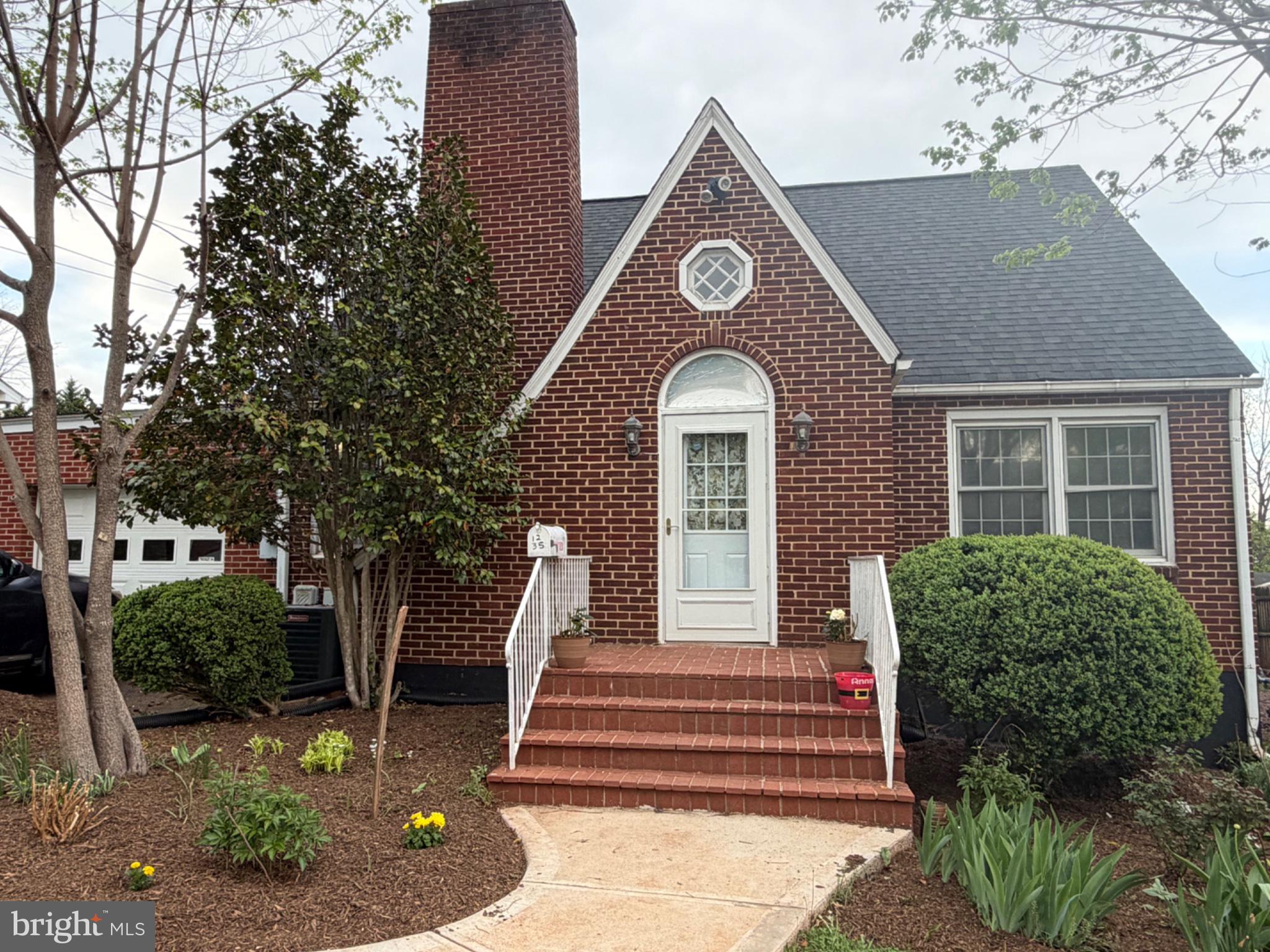1235 South Blue Ridge Avenue Culpeper, VA 22701 - Photo 2 of 20 Charming brick home with lush greenery.