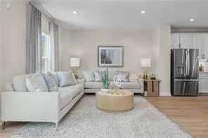 a living room with furniture and a refrigerator