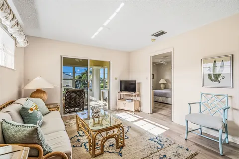 a living room with furniture a flat screen tv and a large window