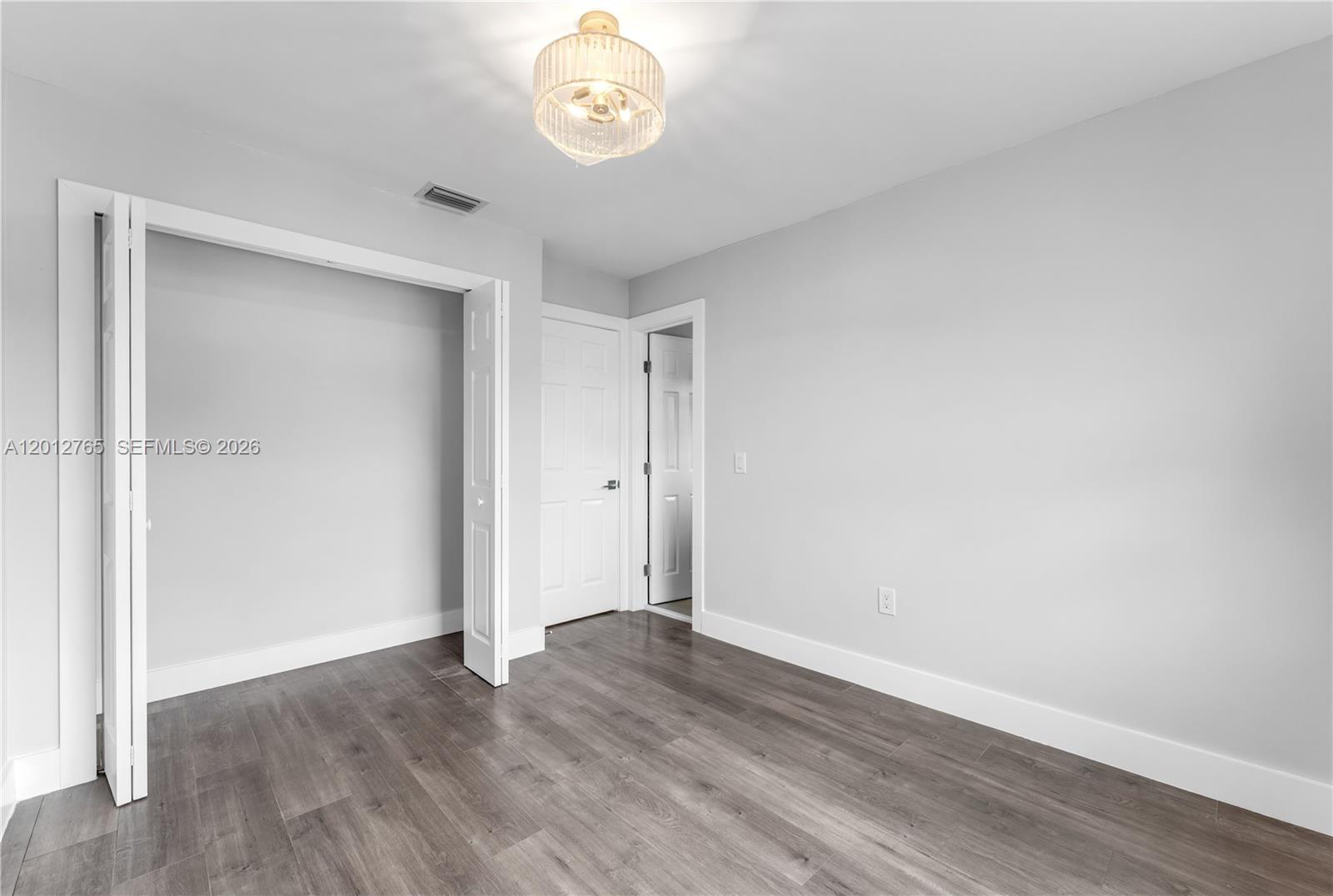 6327 Southwest 127th Place Miami, FL 33183 - Photo 17 of 48 an empty room with wooden floor and windows