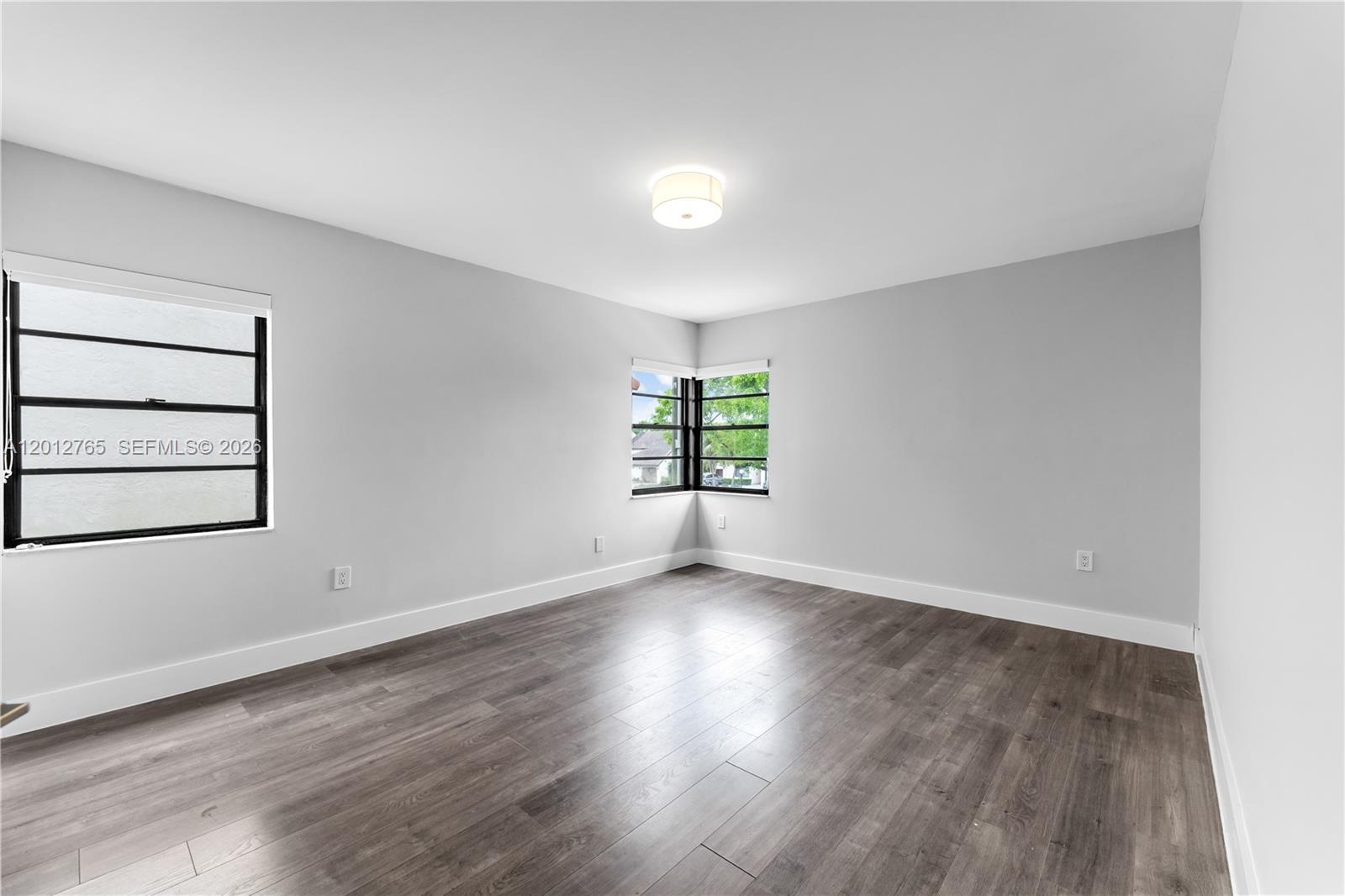 6327 Southwest 127th Place Miami, FL 33183 - Photo 18 of 48 an empty room with wooden floor and windows