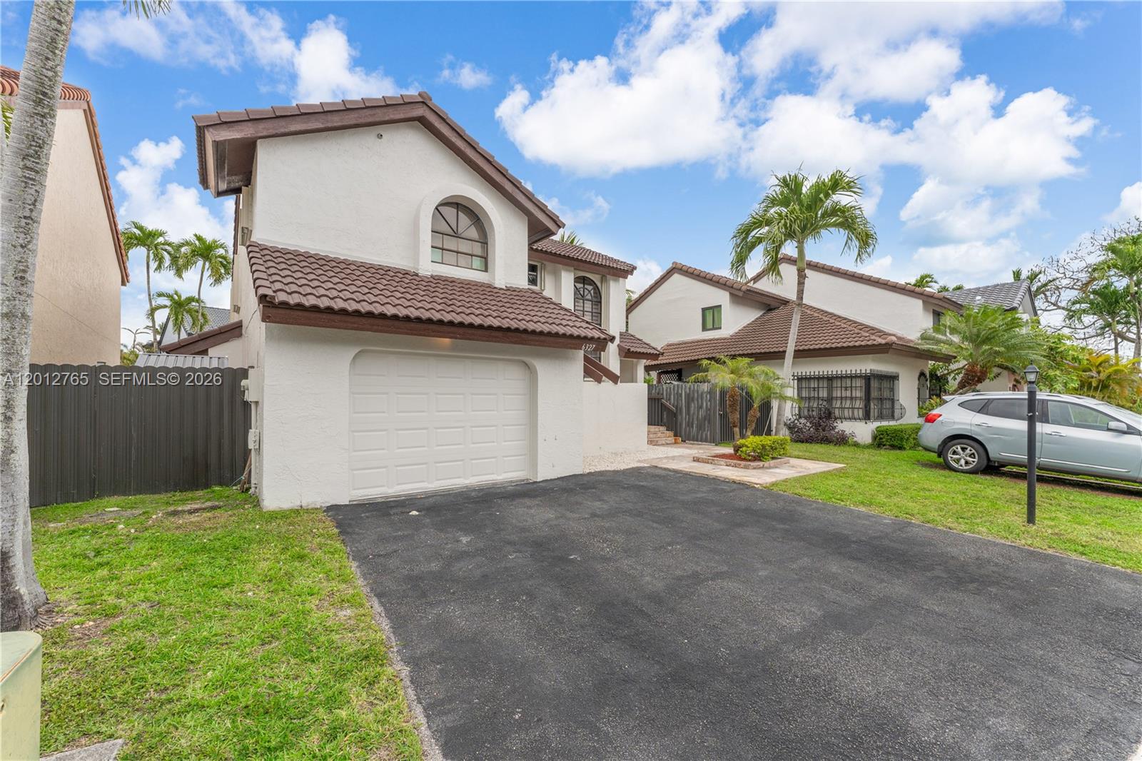 6327 Southwest 127th Place Miami, FL 33183 - Photo 2 of 48 a front view of a house with a yard and garage