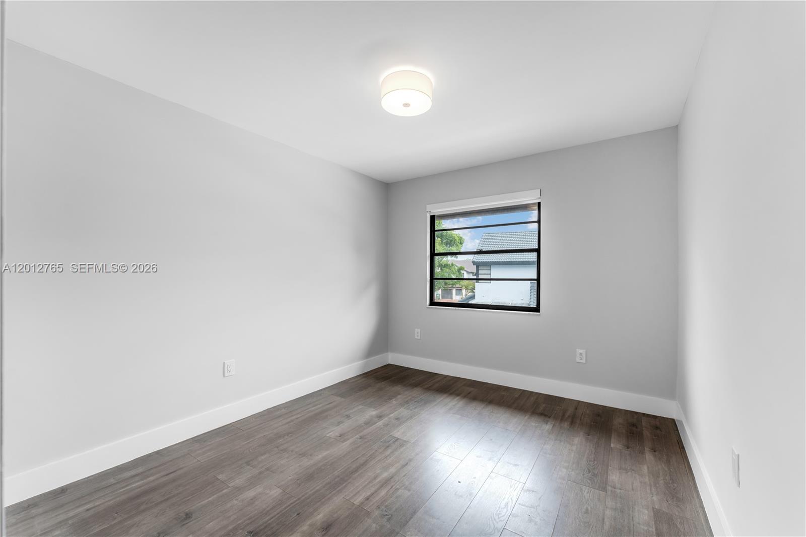 6327 Southwest 127th Place Miami, FL 33183 - Photo 24 of 48 an empty room with wooden floor and windows