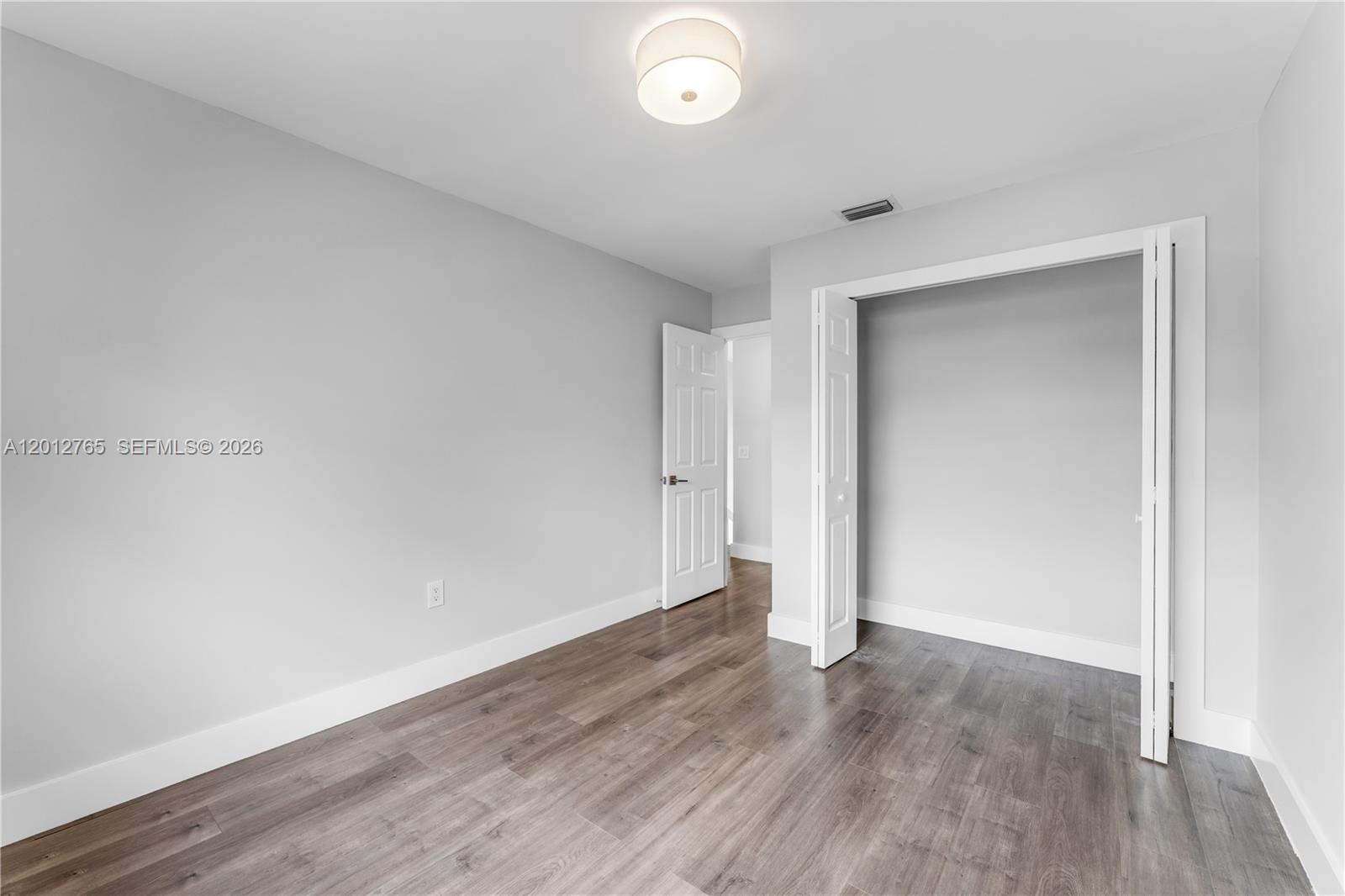 6327 Southwest 127th Place Miami, FL 33183 - Photo 25 of 48 an empty room with wooden floor and windows